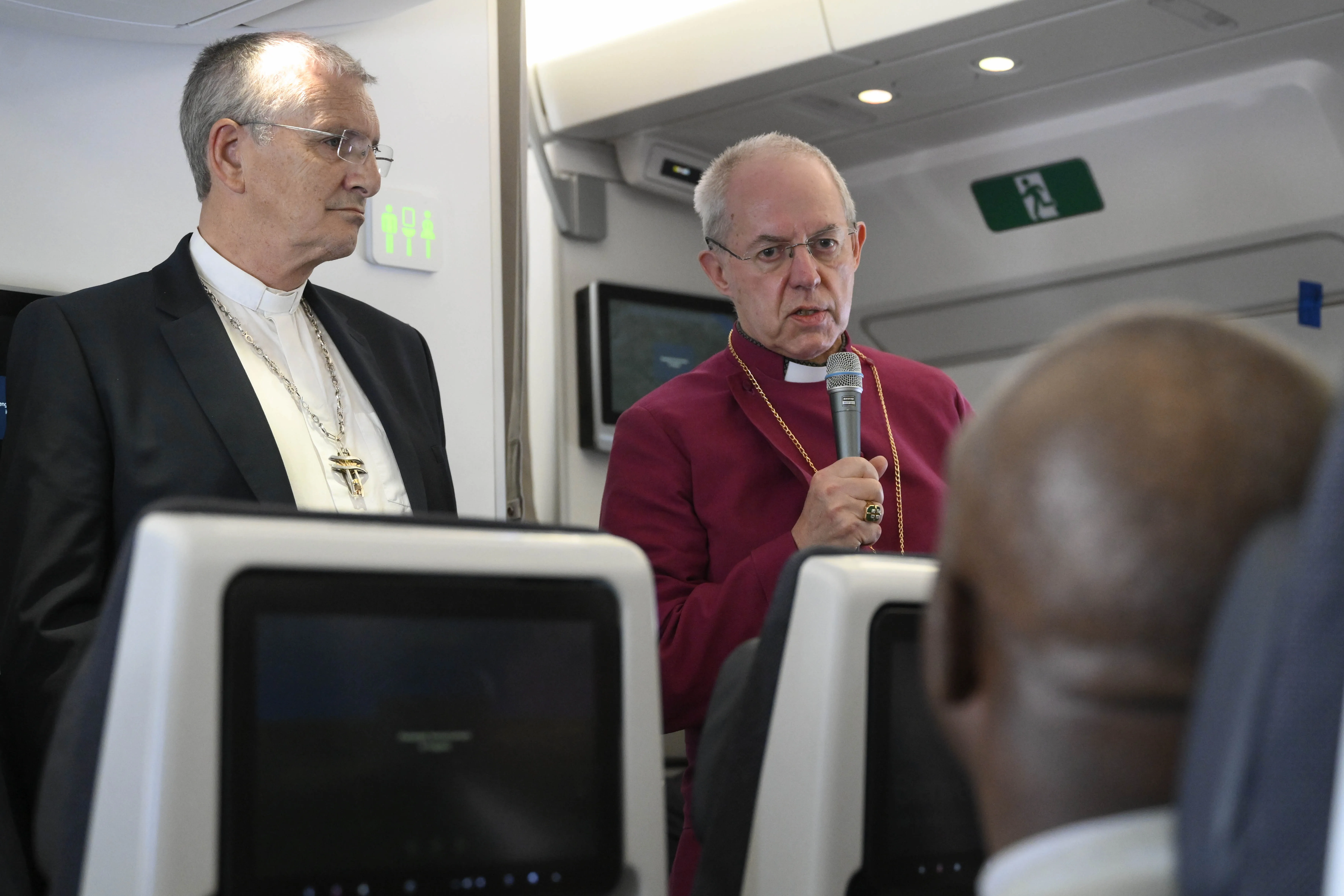 Justin Welby, archbishop of Canterbury, speaks to reporters aboard the papal flight to Rome on Feb. 5, 2023, as Iain Greenshields, moderator of the General Assembly of the Church of Scotland, looks on. The two religious leaders accompanied Pope Francis on his visit to South Sudan. Vatican Media