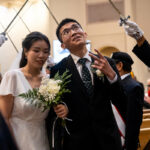 A groom flashes a peace sign at wedding-goers while processing out of St. Mary’s Church in Vancouver after having his marriage sacramentally blessed at the Marriage Mass on October 19. (Nicholas Elbers Photos)