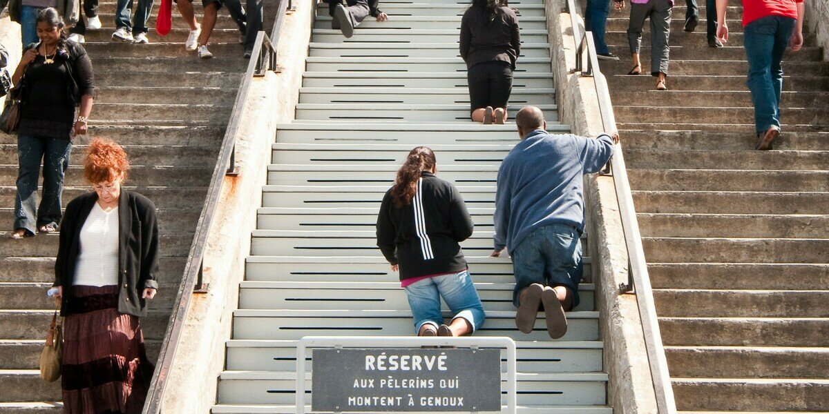 Pilgrims climb the stairs on their knees at Montreal’s St. Joseph’s Oratory. A federal politician asked if the practice would be banned under Quebec Premier François Legault’s proposal to prevent public prayer. (Michael Swan/The Catholic Register)