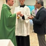 Knights of Columbus insurance salesman Mark Pan receives Communion from Father Maciej Wos at the Business Consecration Mass at St. Clare of Assisi Church in Coquitlam. (Submitted Photos)