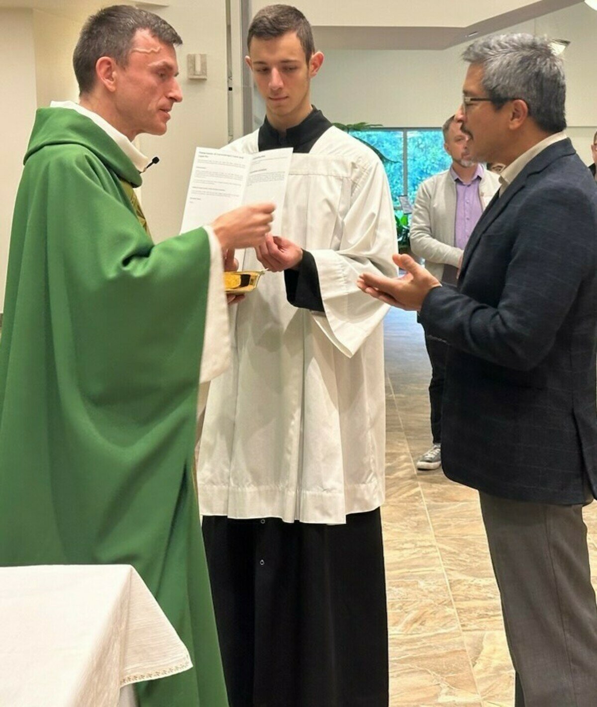 Knights of Columbus insurance salesman Mark Pan receives Communion from Father Maciej Wos at the Business Consecration Mass at St. Clare of Assisi Church in Coquitlam. (Submitted Photos)